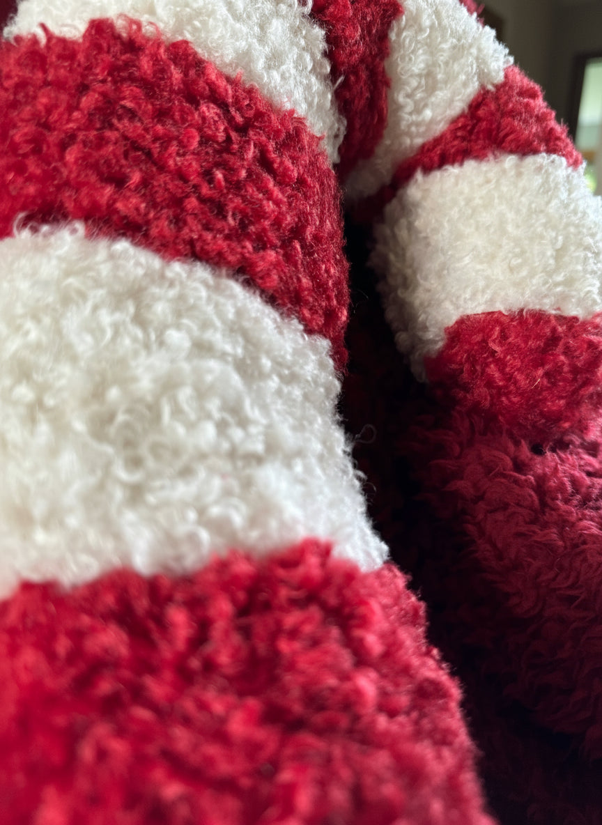 Close-up of a red and white textured fabric Candy cane cushion.