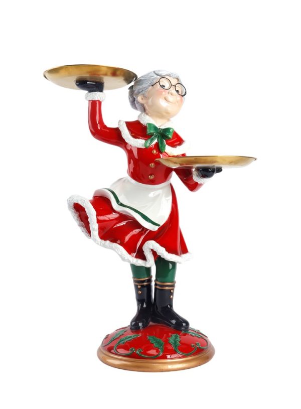 A festive Christmas-themed figurine of an elderly female waiter or server wearing a red and white holiday dress with green accents, holding two gold-colored trays, standing on a decorated red and gold base against a white background.