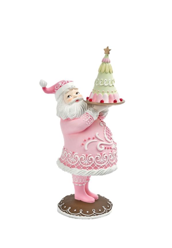 A festive Santa Claus figurine wearing a pink outfit and holding a decorated cake on a silver tray, set against a plain white background.