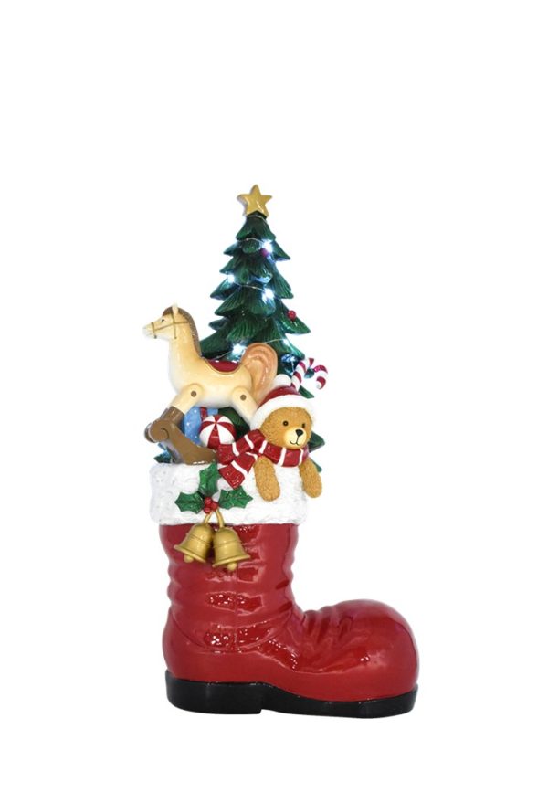 A Christmas-themed boot figurine with a red boot base, white cuff, green tree, horse, teddy bear, candy canes, and gold bells on a plain white background.